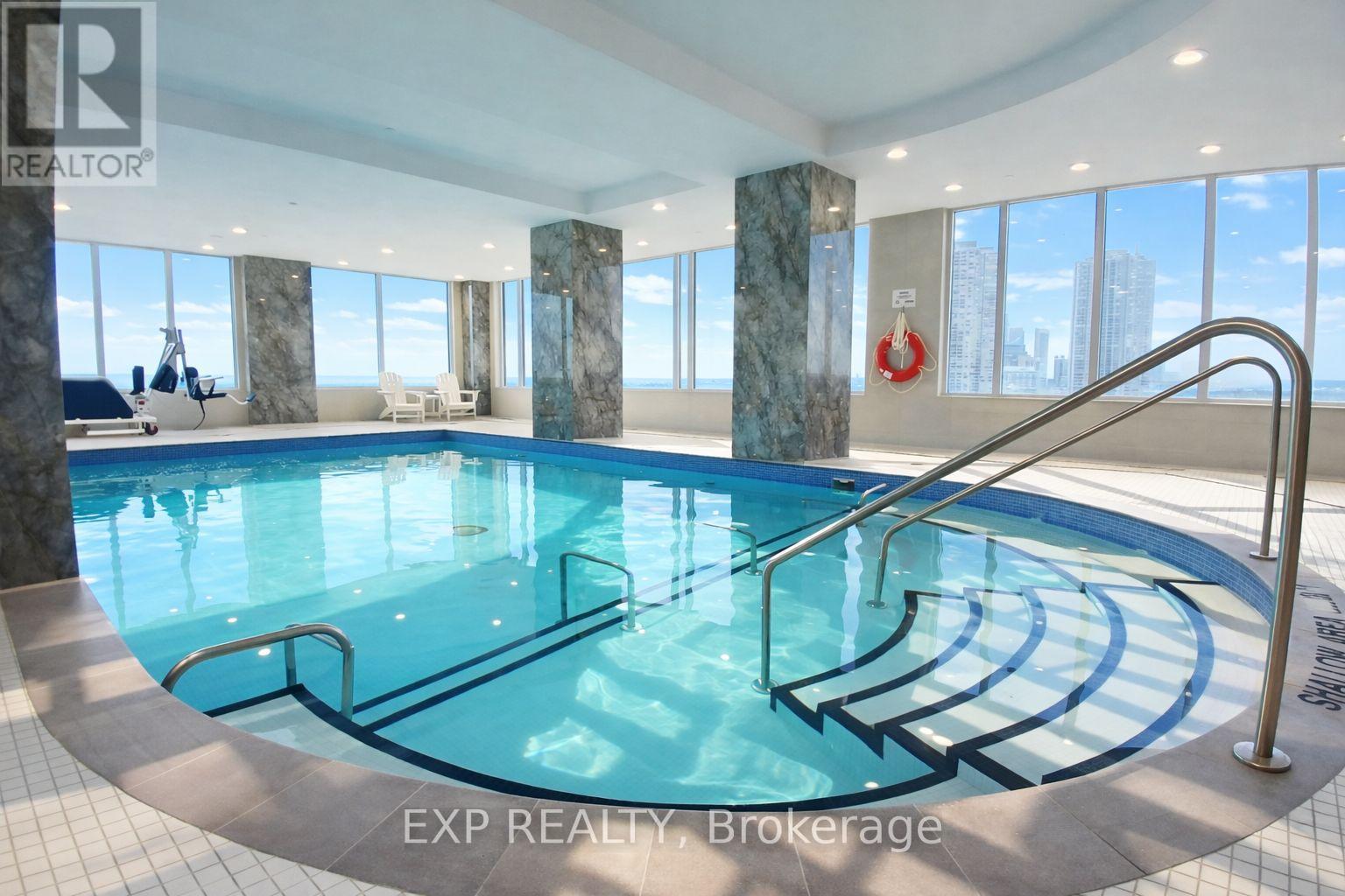 A large indoor pool with a metal railing around it.