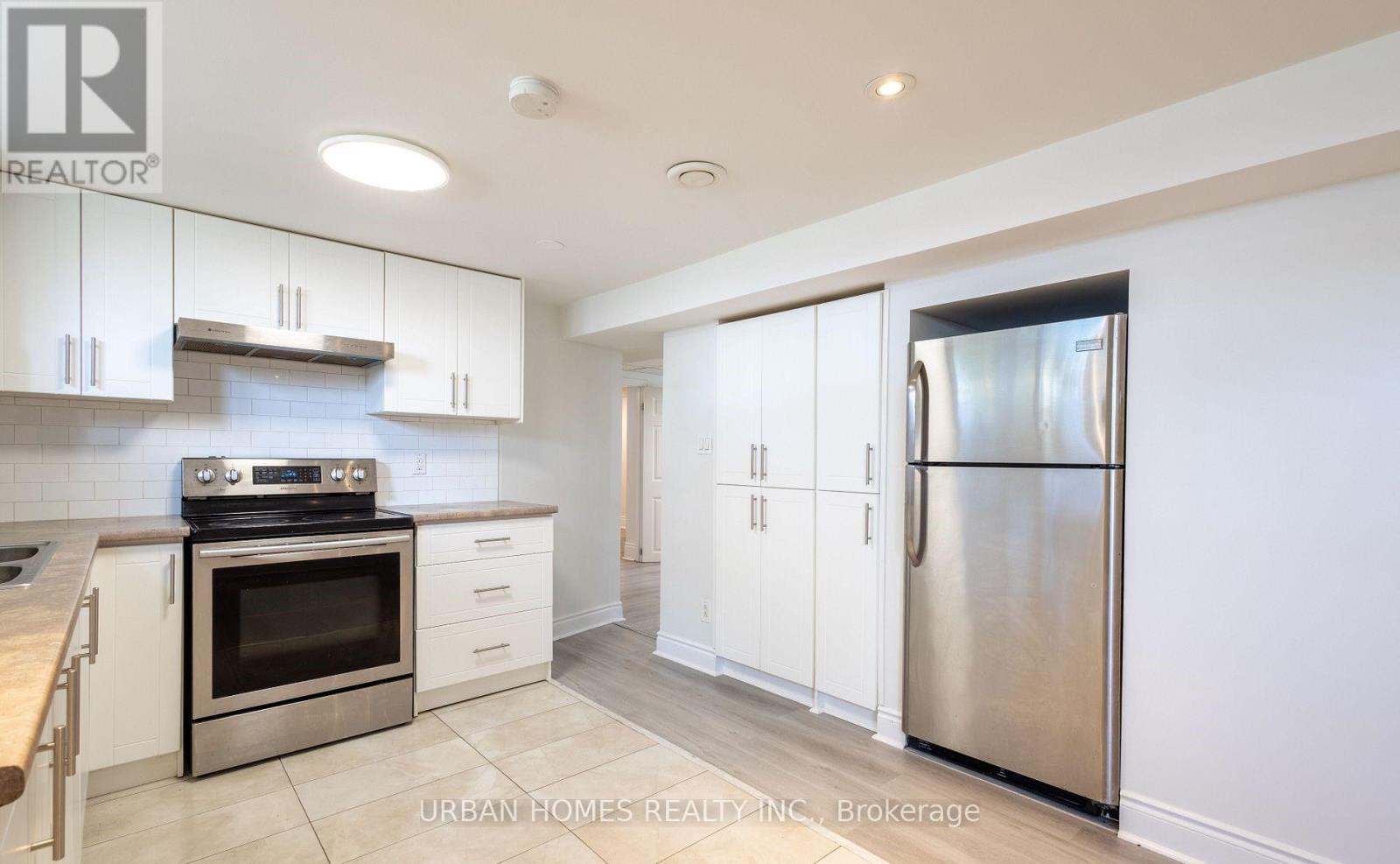A modern kitchen with stainless steel appliances and white cabinets.