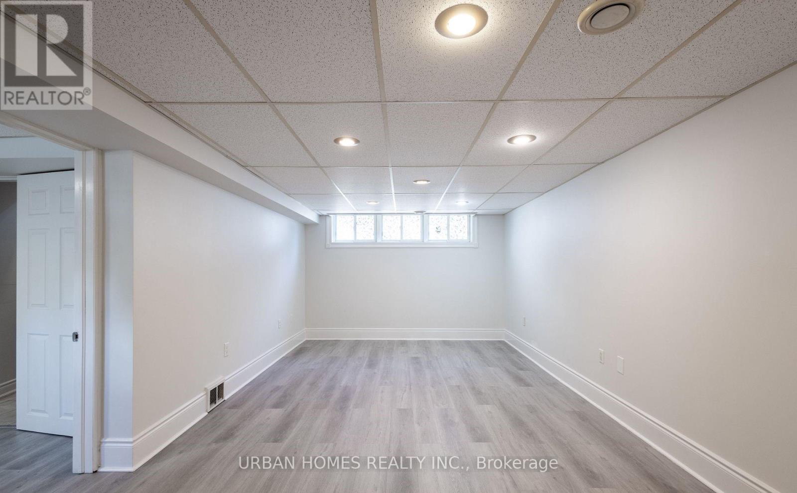 A spacious room with a door on the left and a window on the right.