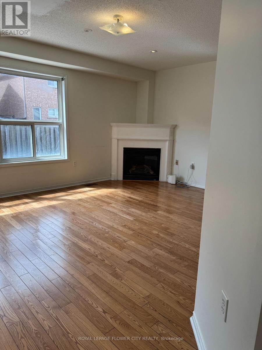 A living room with a fireplace and wood flooring.