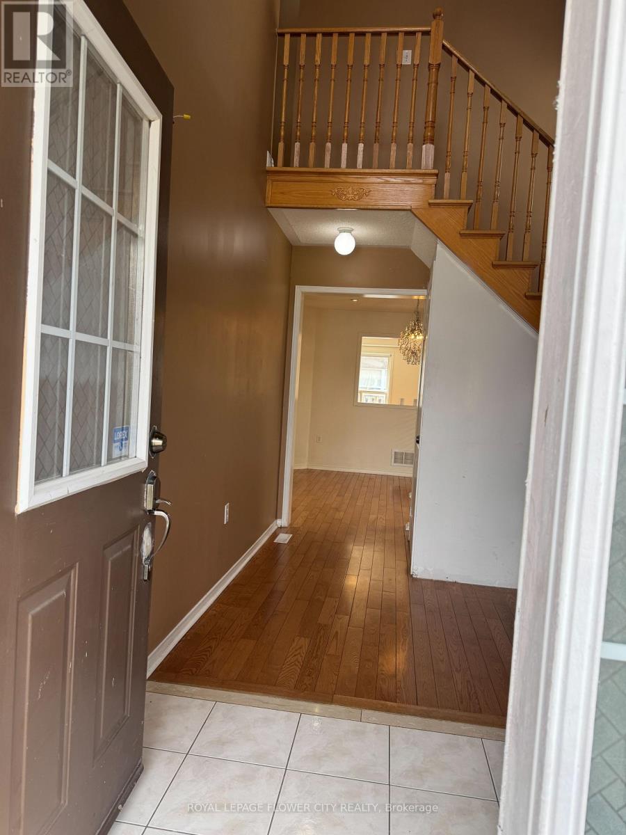 A hallway with a wooden staircase and a white door.