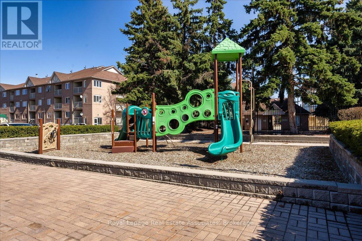 A playground with a green slide and a wooden swing set.