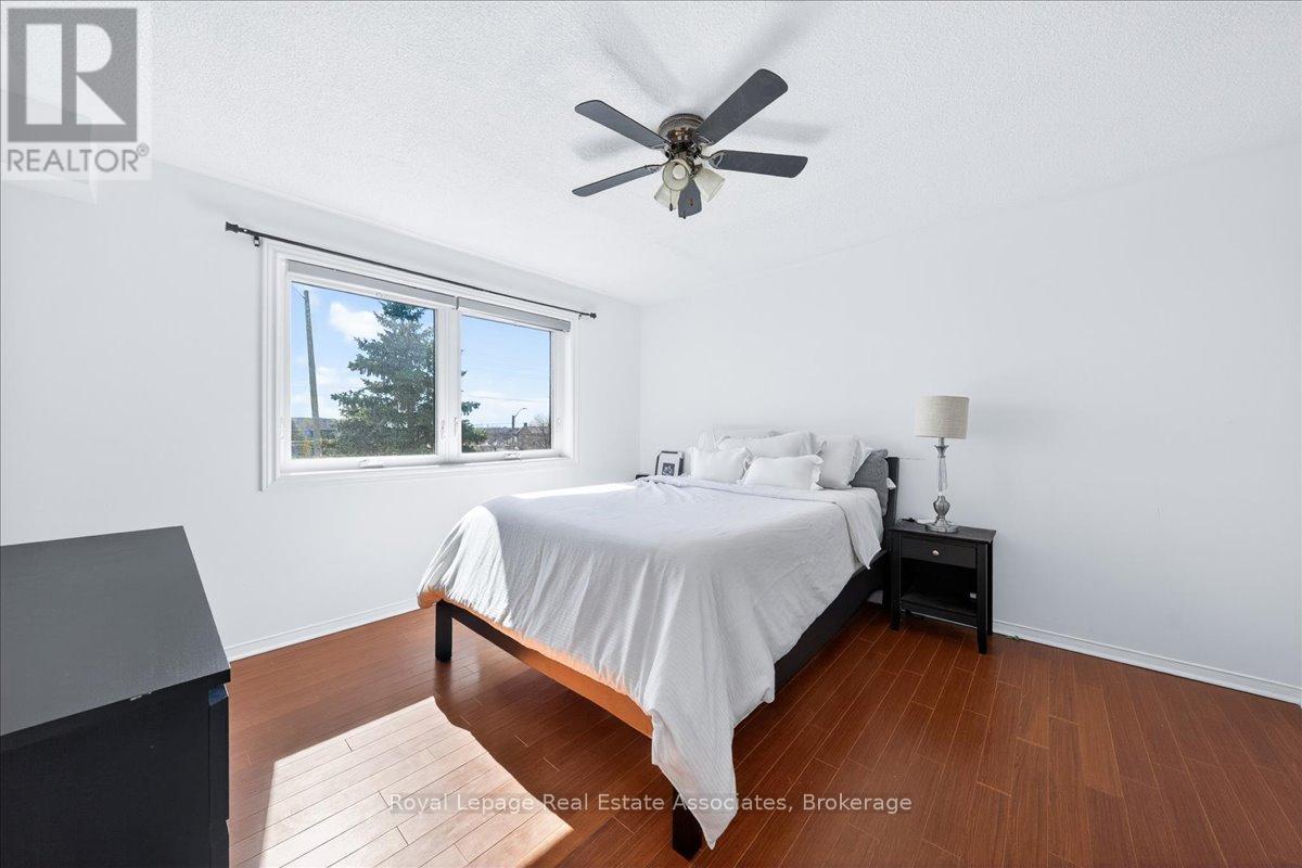 A bedroom with a bed, nightstand, and window.