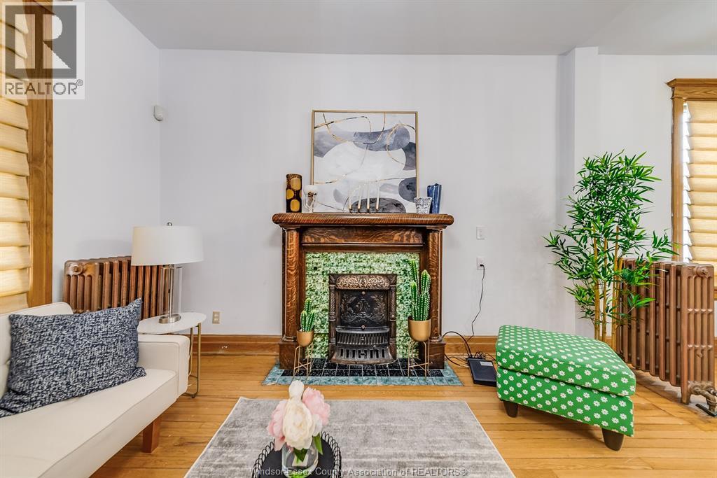 A living room with a fireplace and a painting above it.