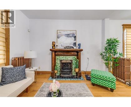 A living room with a fireplace and a painting above it.