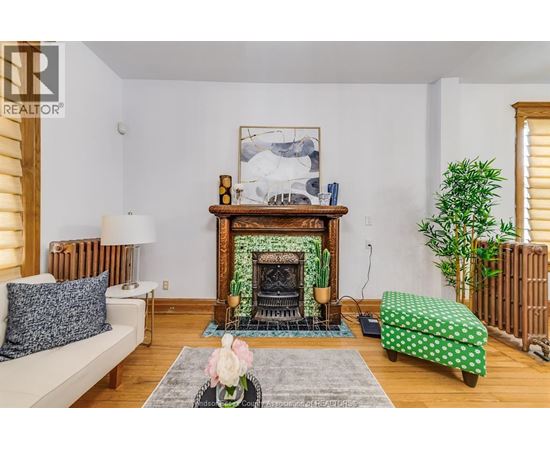 A living room with a fireplace and a painting above it.