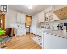A kitchen with white cabinets and a wooden floor.