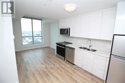 A kitchen with white cabinets and a black dishwasher.