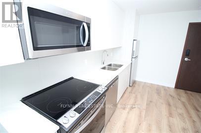 A kitchen with a stove top oven and a microwave above it.