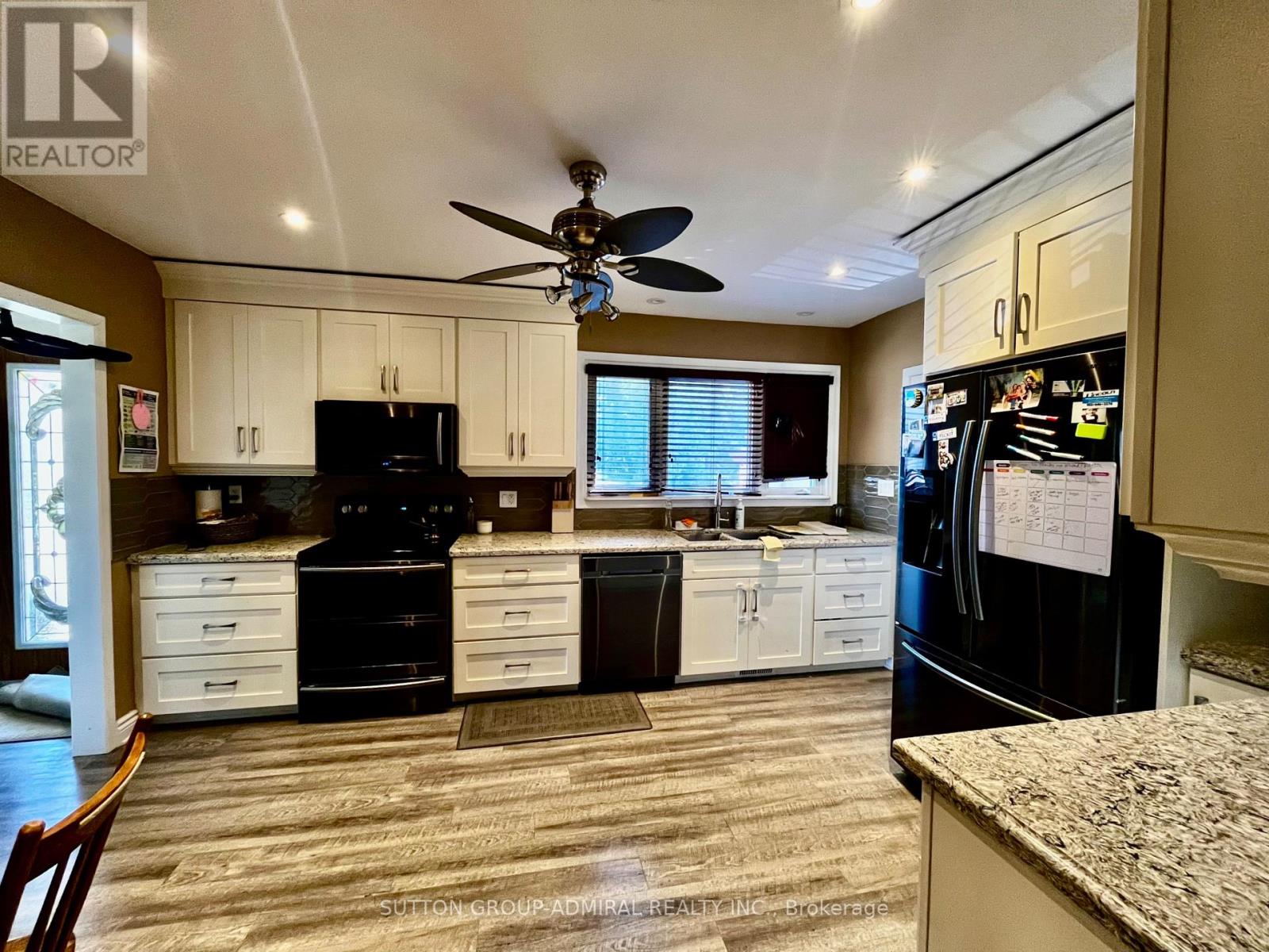 A kitchen with black appliances and white cabinets.
