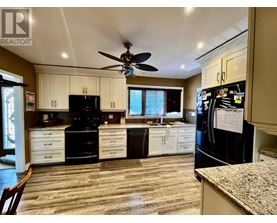 A kitchen with black appliances and white cabinets.