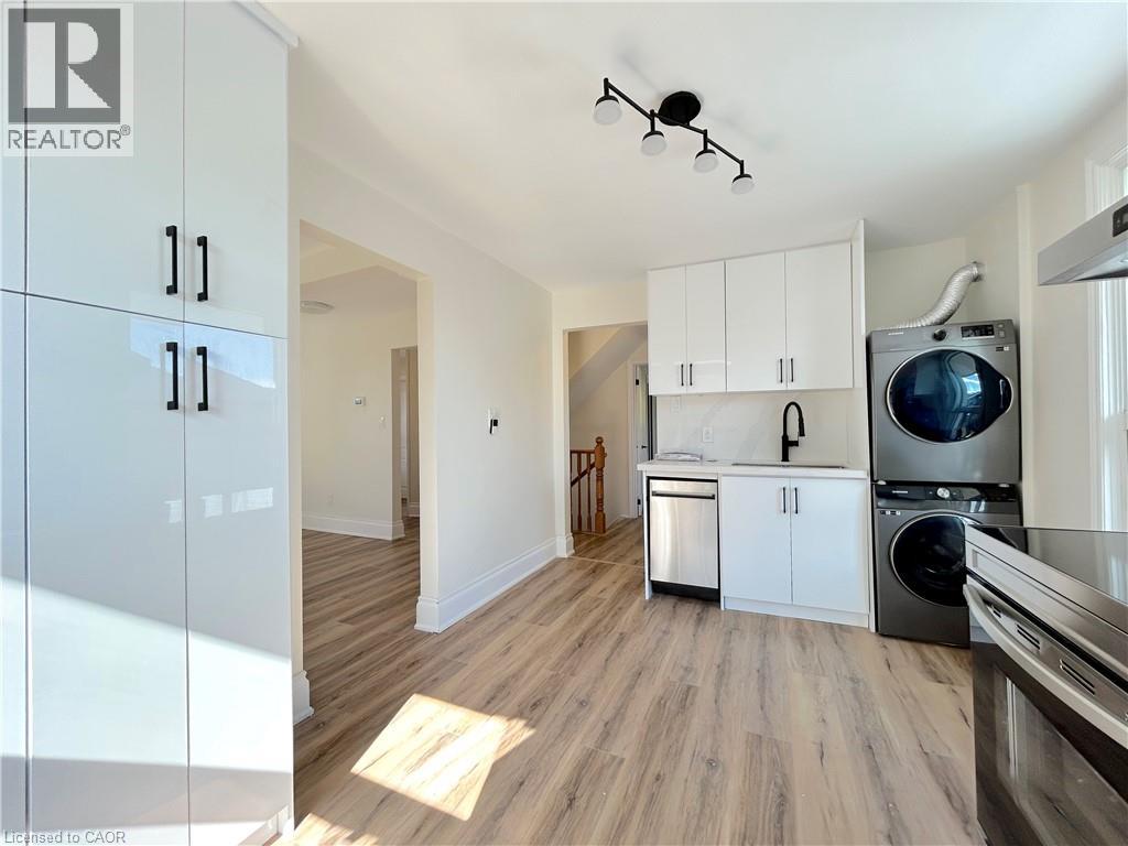 A kitchen with white cabinets and a washing machine.