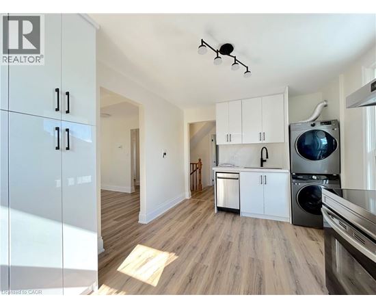 A kitchen with white cabinets and a washing machine.