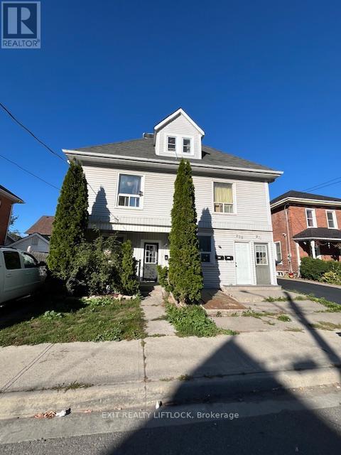 A house with a white exterior and a grey roof is for sale.