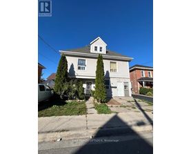 A house with a white exterior and a grey roof is for sale.