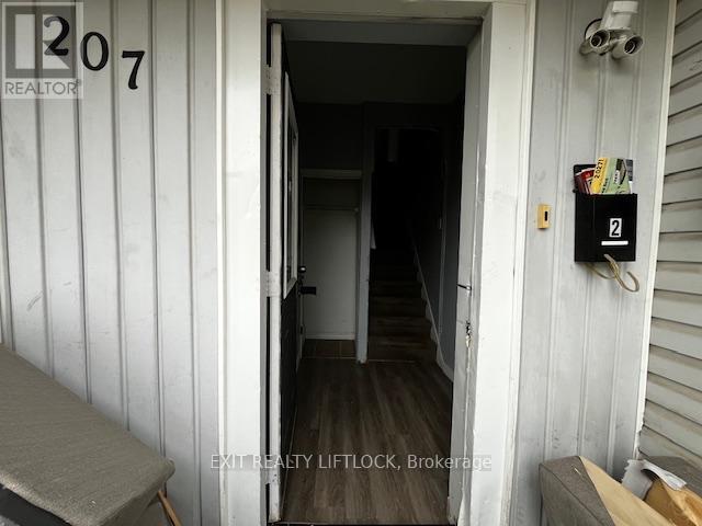 A white door with a number 207 on it and a sign that says REALTOR.