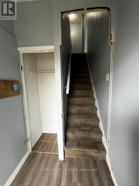 A stairway leading to a doorway with a sign that says EXIT REALTY LIFTLOCK Brokerage.