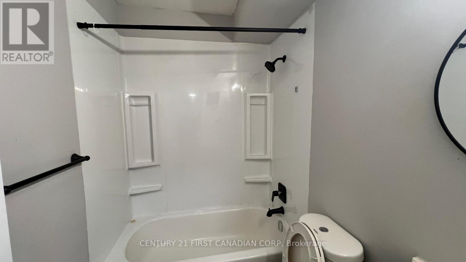 A white bathroom with a tub and toilet.