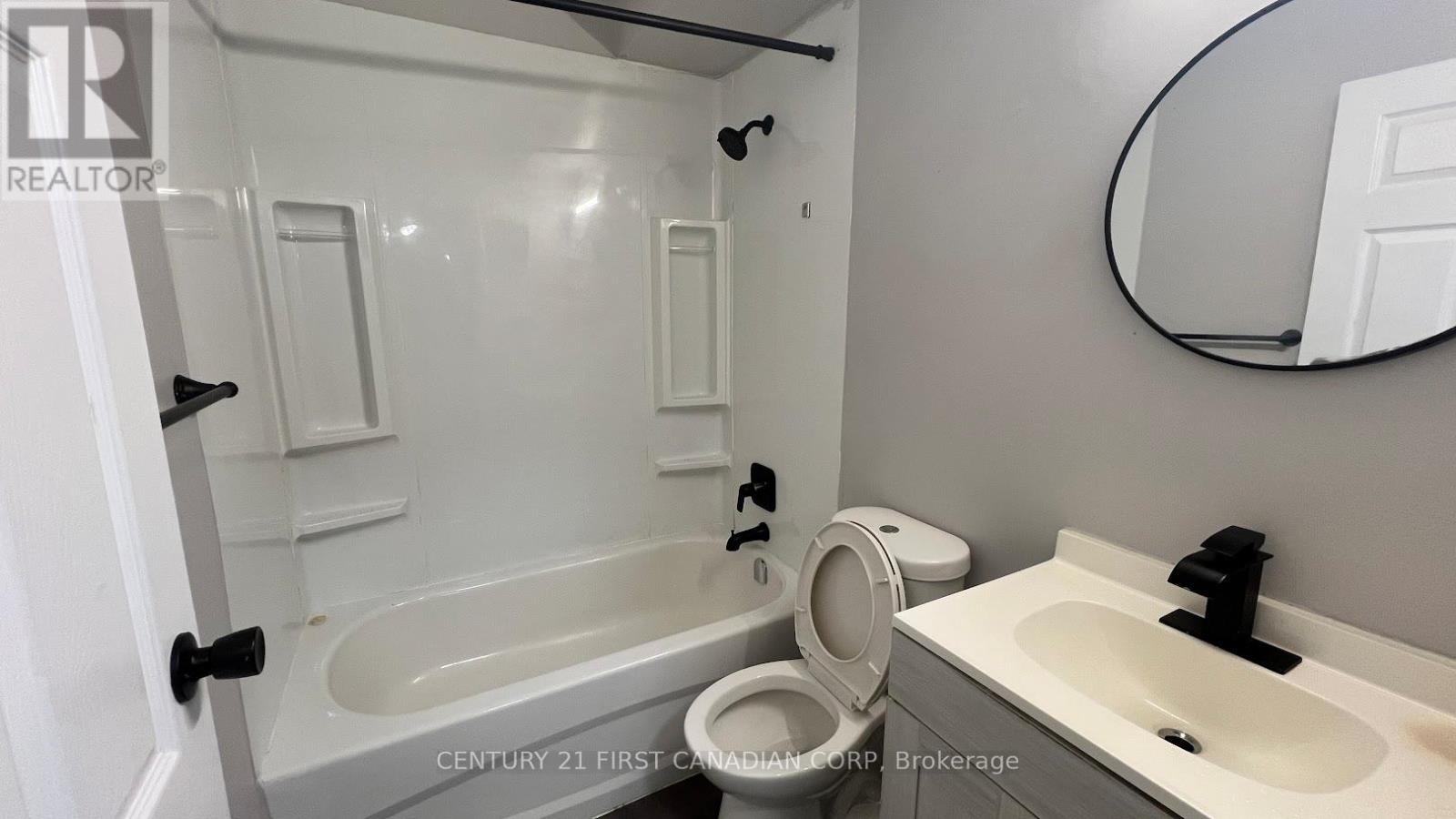 A bathroom with a tub, toilet, and sink.