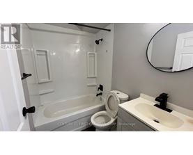 A bathroom with a tub, toilet, and sink.