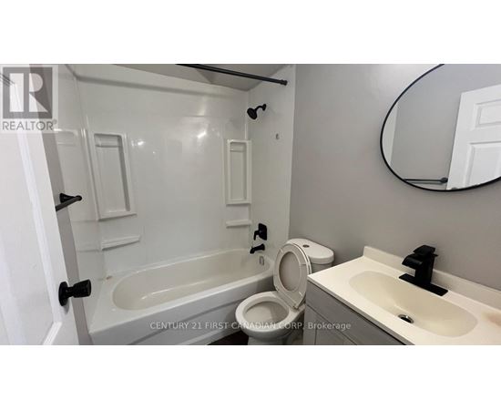 A bathroom with a tub, toilet, and sink.