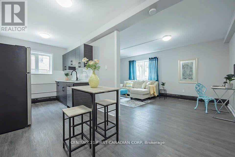 A well-lit kitchen and living room with a dining table and chairs.