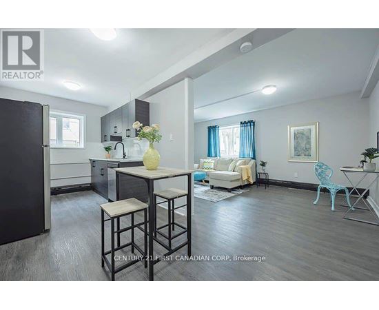 A well-lit kitchen and living room with a dining table and chairs.