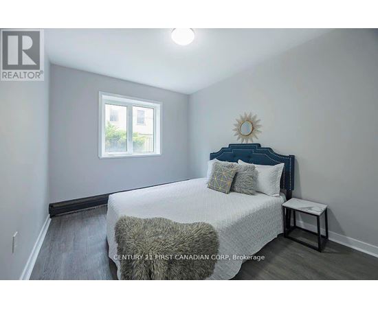 A bedroom with a bed, pillows, and a window.