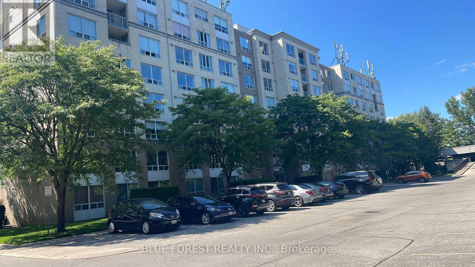 A parking lot with cars and apartment buildings.