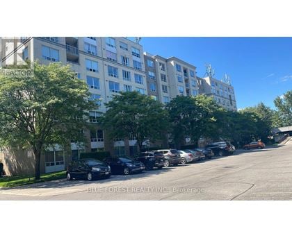 A parking lot with cars and apartment buildings.