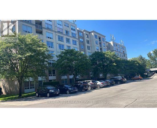 A parking lot with cars and apartment buildings.