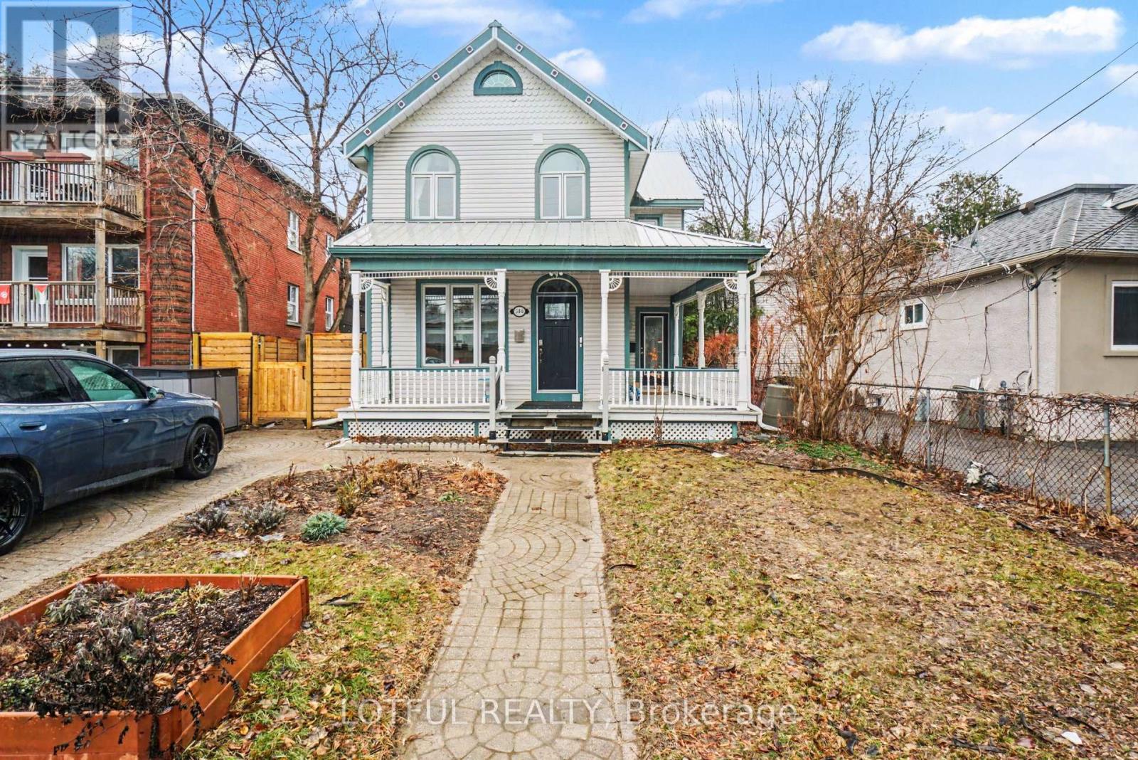 A house with a green roof and a white porch.