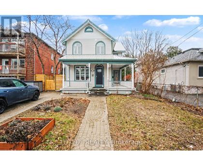 A house with a green roof and a white porch.