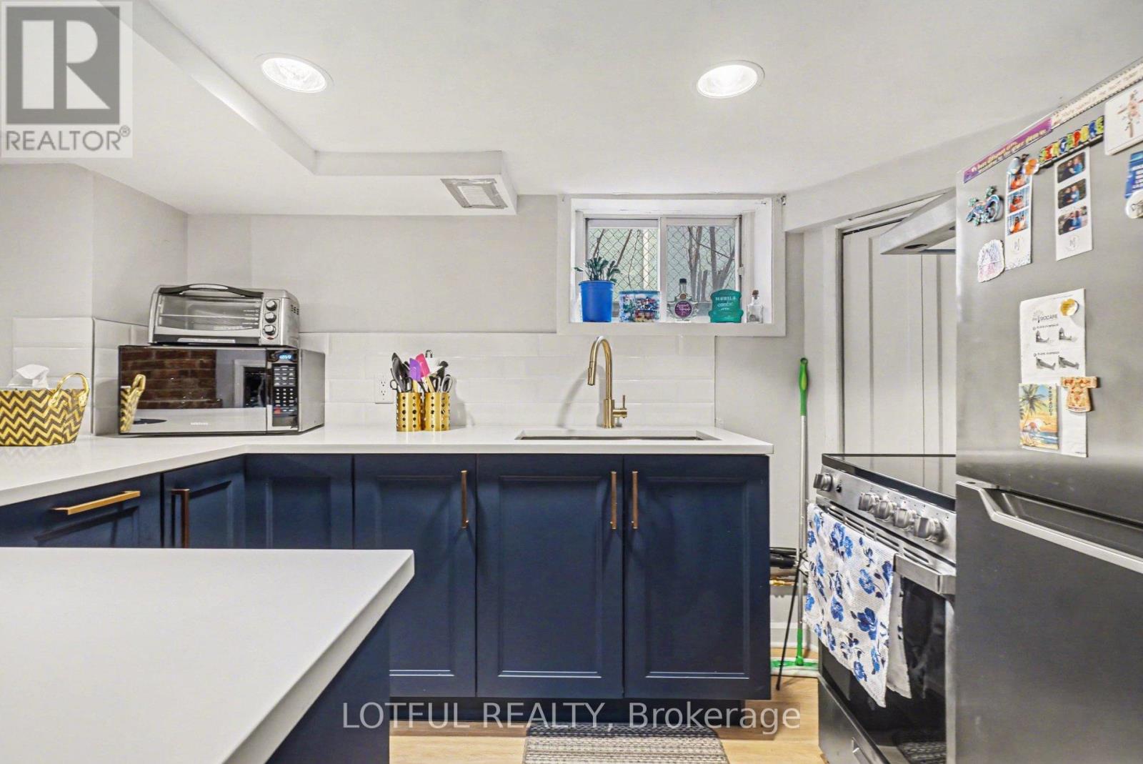 A kitchen with a white counter top and blue cabinets.