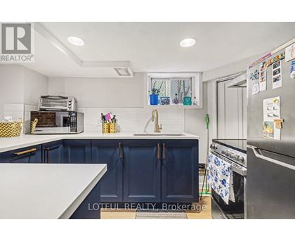 A kitchen with a white counter top and blue cabinets.