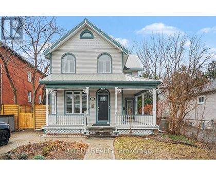 A house with a green roof and a porch with white railings.