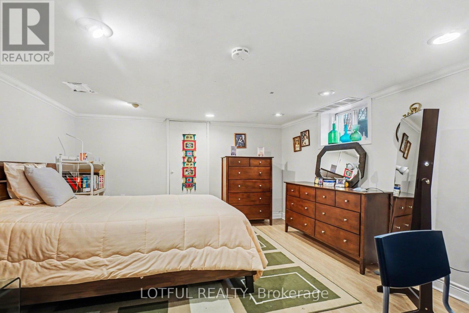 A bedroom with a bed, dresser, and chair.
