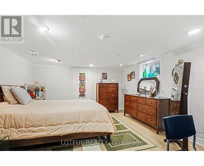 A bedroom with a bed, dresser, and chair.