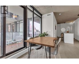 A dining area with a wooden table and grey chairs.