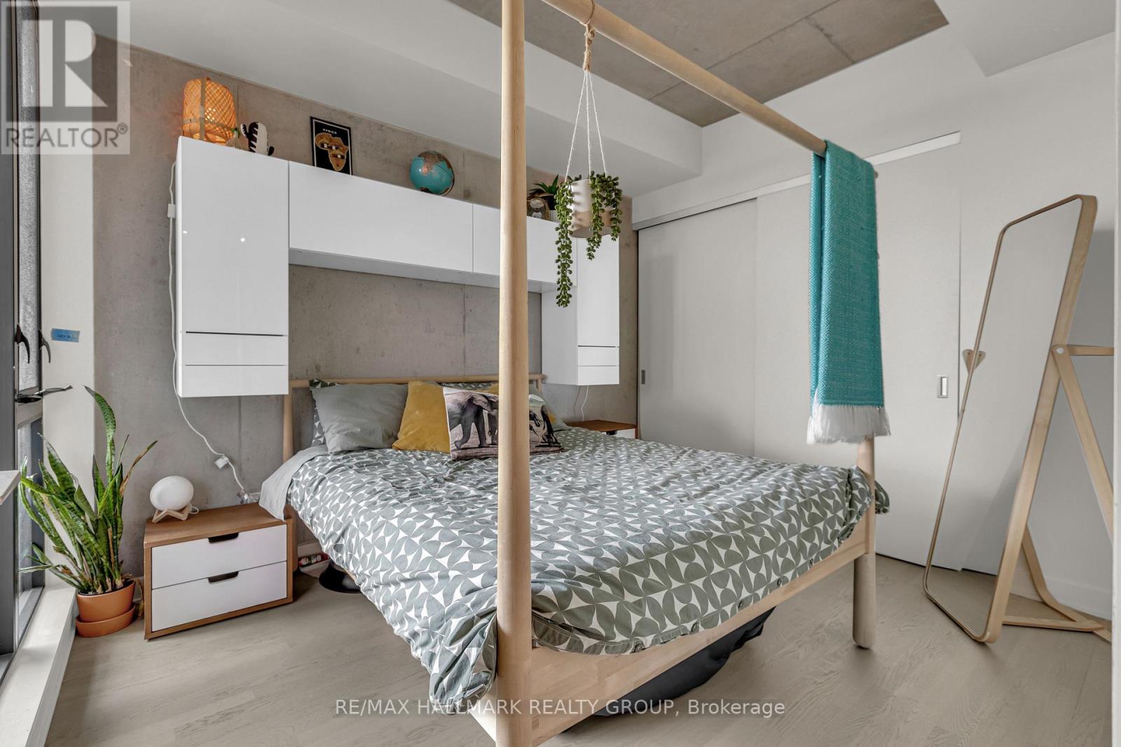 A bedroom with a four poster bed and a hanging plant.