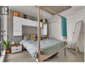 A bedroom with a four poster bed and a hanging plant.