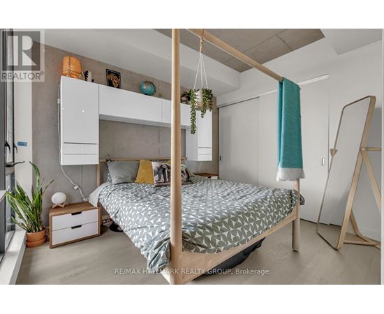 A bedroom with a four poster bed and a hanging plant.