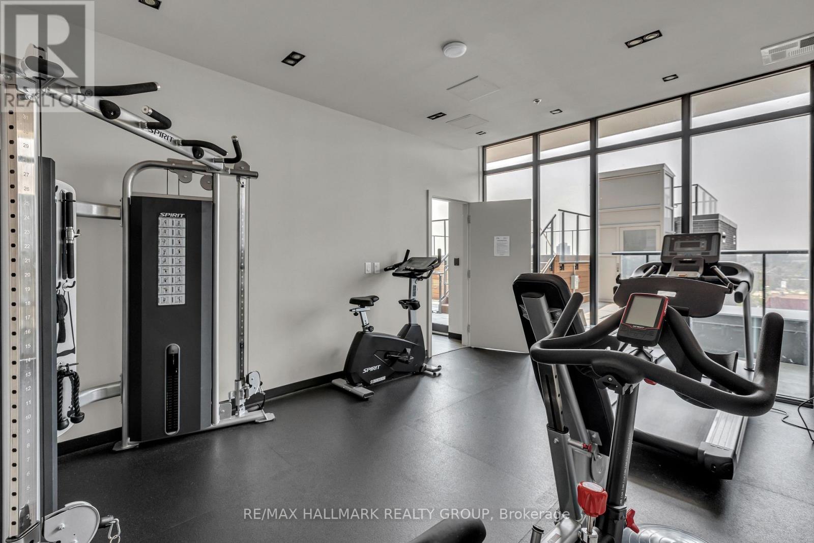 A gym with a row of treadmills and a row of weight machines.