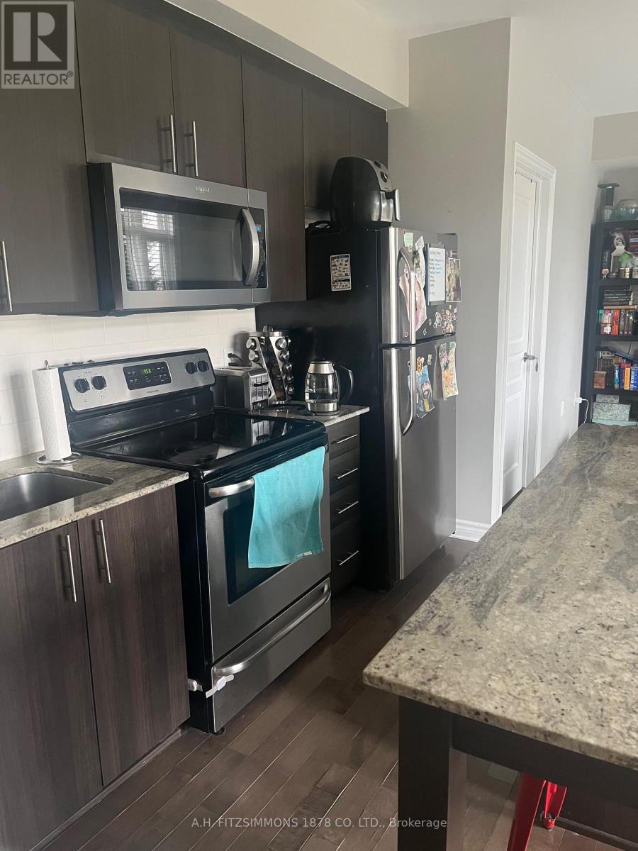A kitchen with a black fridge and stove top oven.