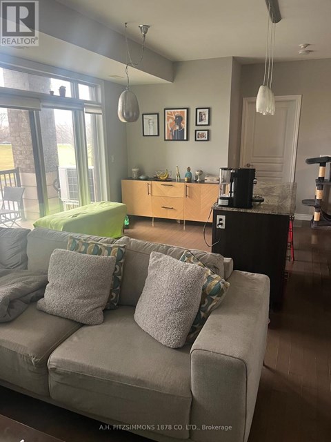 A living room with a grey couch and a wooden cabinet.