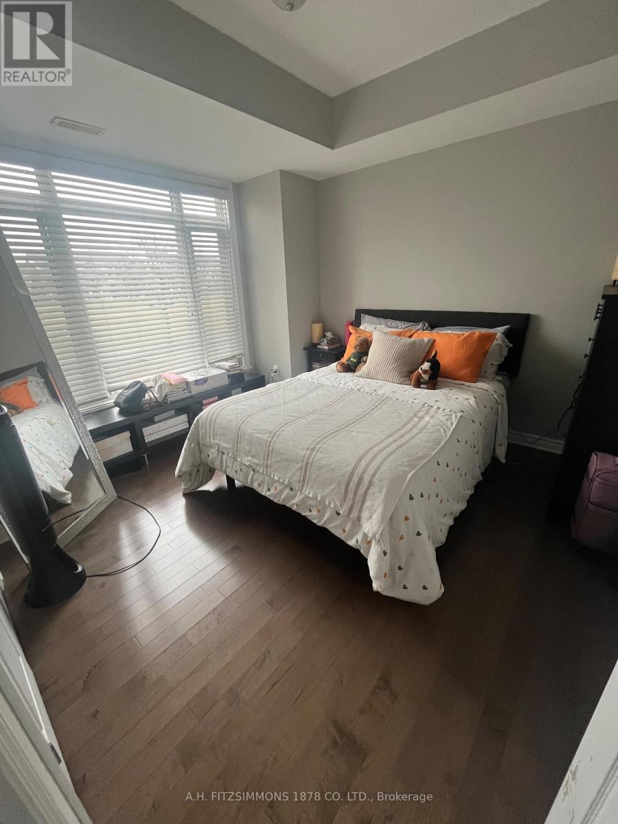 A bedroom with a large bed and wooden floors.