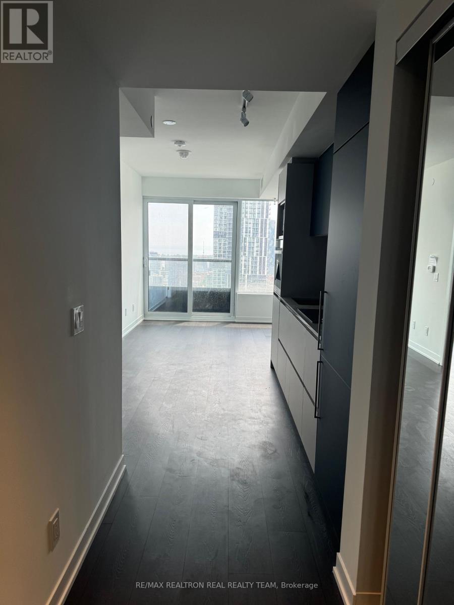 A hallway with a window and a door leading to a kitchen.
