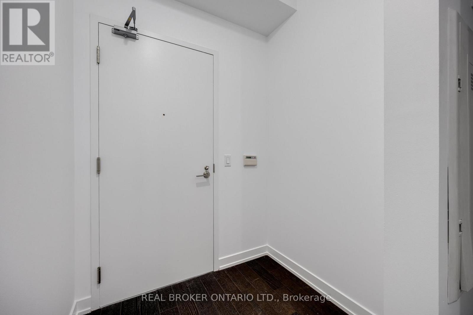 A white door with a Real Broker logo on it.