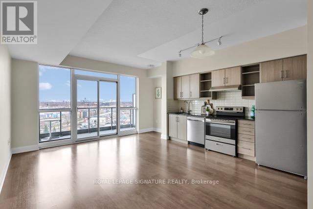 A well-lit kitchen with wooden floors and stainless steel appliances.