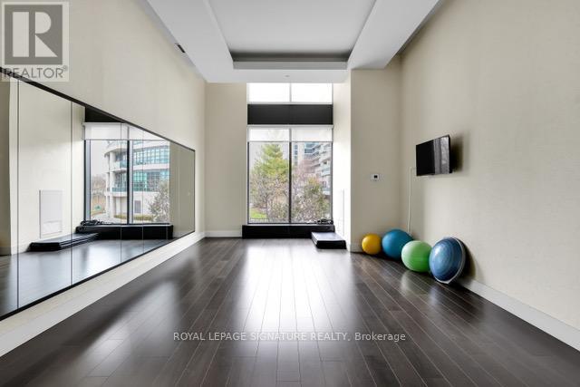 A spacious room with wooden floors and a row of exercise balls.